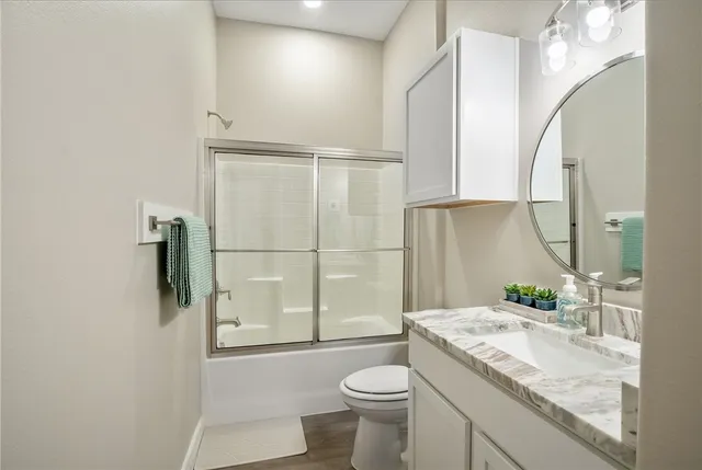 a bathroom with a granite countertop sink toilet and shower