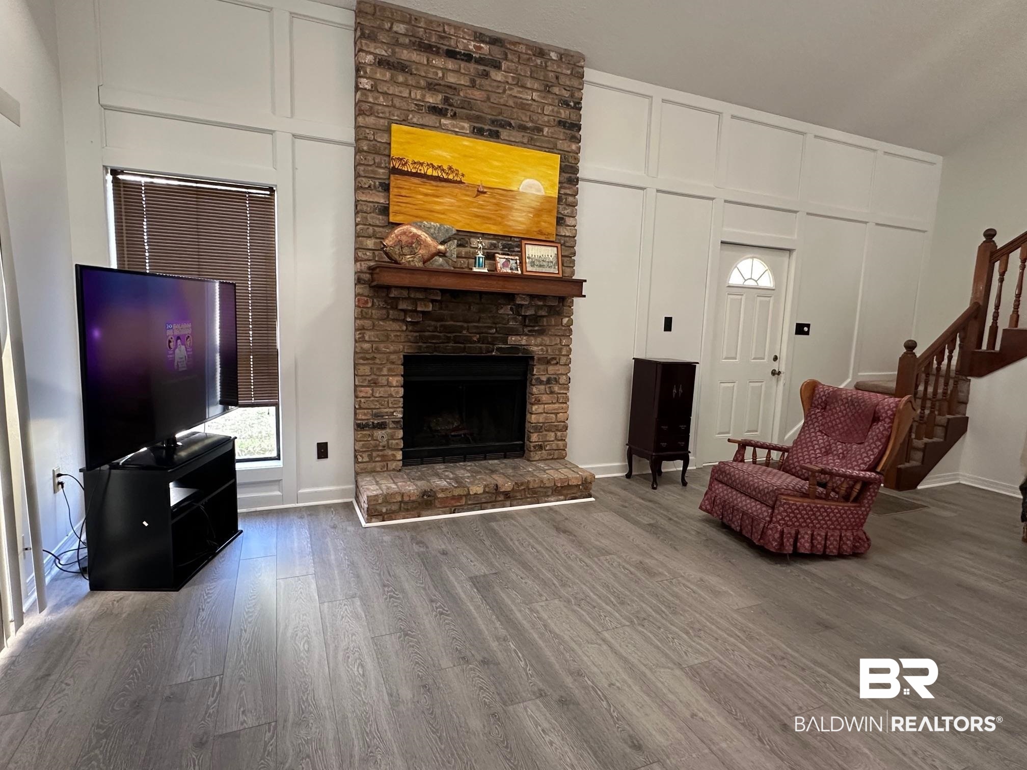 6533 Cedar Bend Court, Unit A Mobile, AL 36608 - Photo 3 of 16 Living room featuring a decorative wall, wood finished floors, and a fireplace