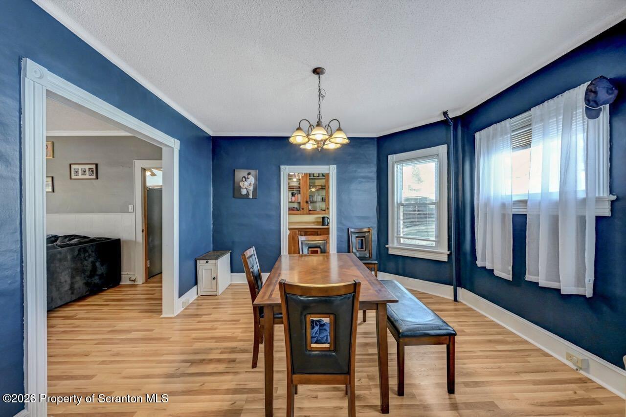 117 West Line Street Olyphant, PA 18447 - Photo 9 of 47 a dining room with wooden floor a chandelier a wooden table and chairs