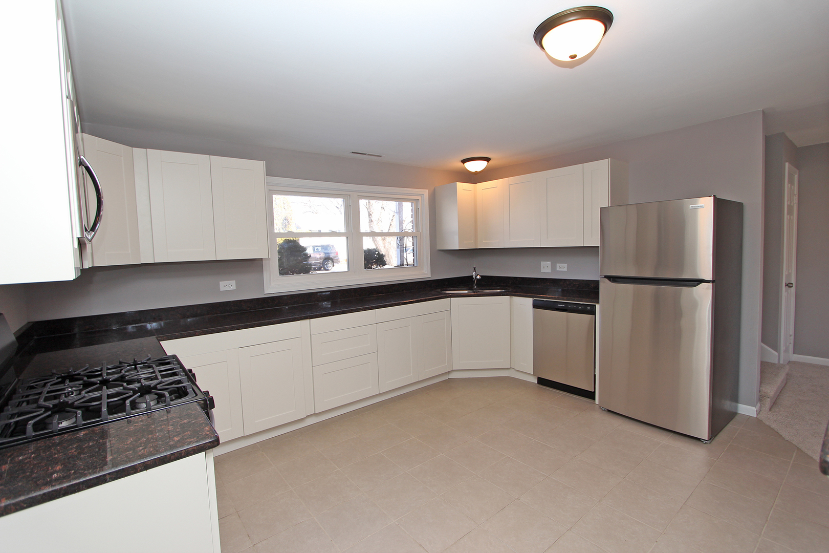 656 Briar Road Wauconda, IL 60084 - Photo 4 of 25 a kitchen with a refrigerator and white cabinets