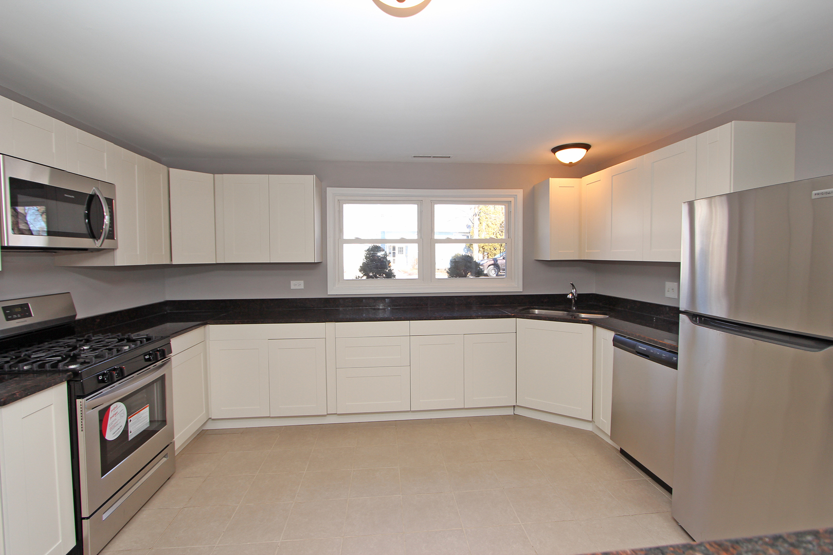 656 Briar Road Wauconda, IL 60084 - Photo 7 of 25 a kitchen with granite countertop a refrigerator and a stove top oven