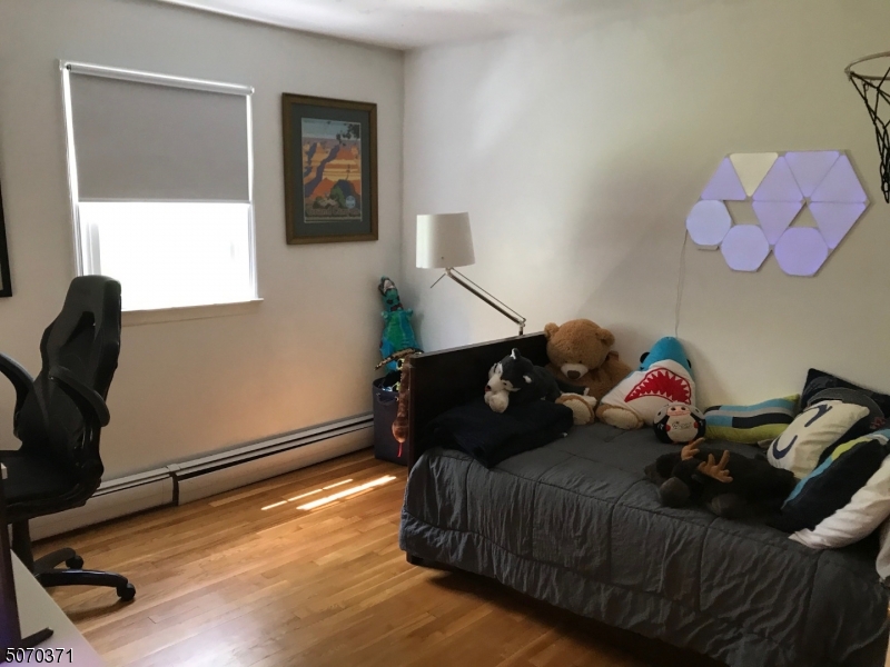 18 Parrott Mill Road Chatham, NJ 07928 - Photo 14 of 19 a bedroom with a bed and wooden floor