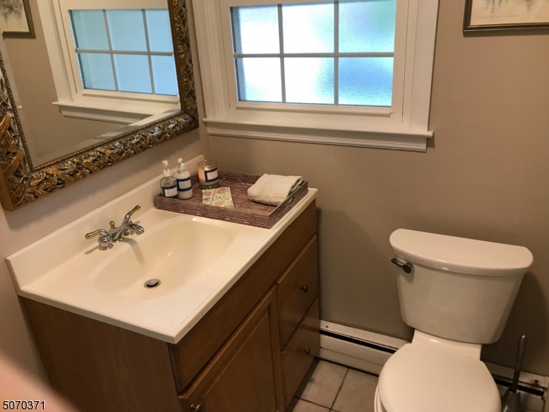 18 Parrott Mill Road Chatham, NJ 07928 - Photo 3 of 19 a bathroom with a sink toilet and mirror
