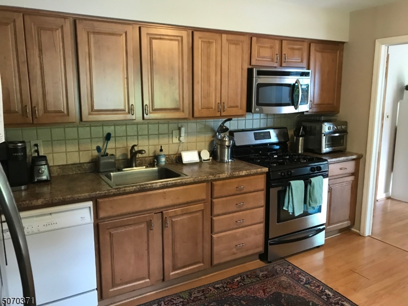 18 Parrott Mill Road Chatham, NJ 07928 - Photo 9 of 19 a kitchen with stainless steel appliances granite countertop a stove a microwave and refrigerator