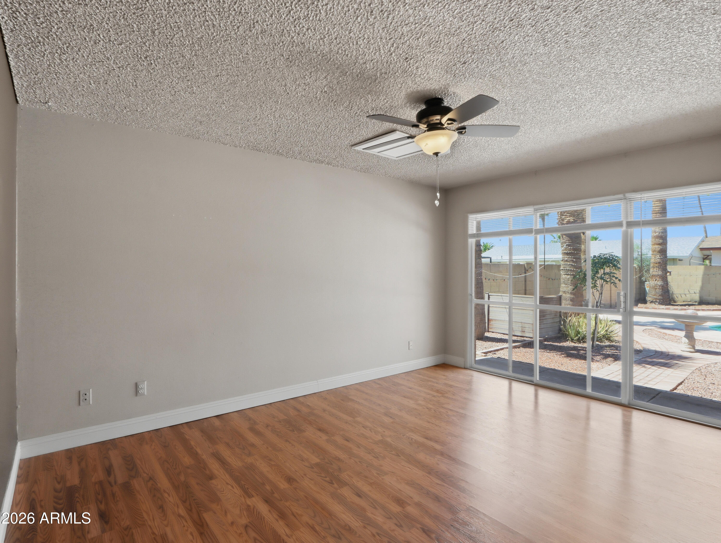 450 Cascada Road Litchfield Park, AZ 85340 - Photo 16 of 40 wooden floor in an empty room with a window