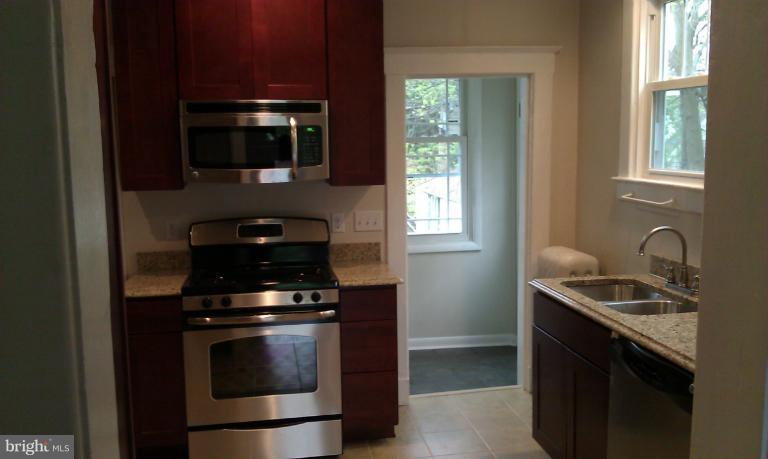 a kitchen with stainless steel appliances granite countertop a sink stove and microwave