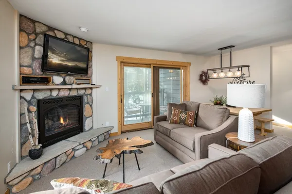a living room with furniture a flat screen tv and a fireplace