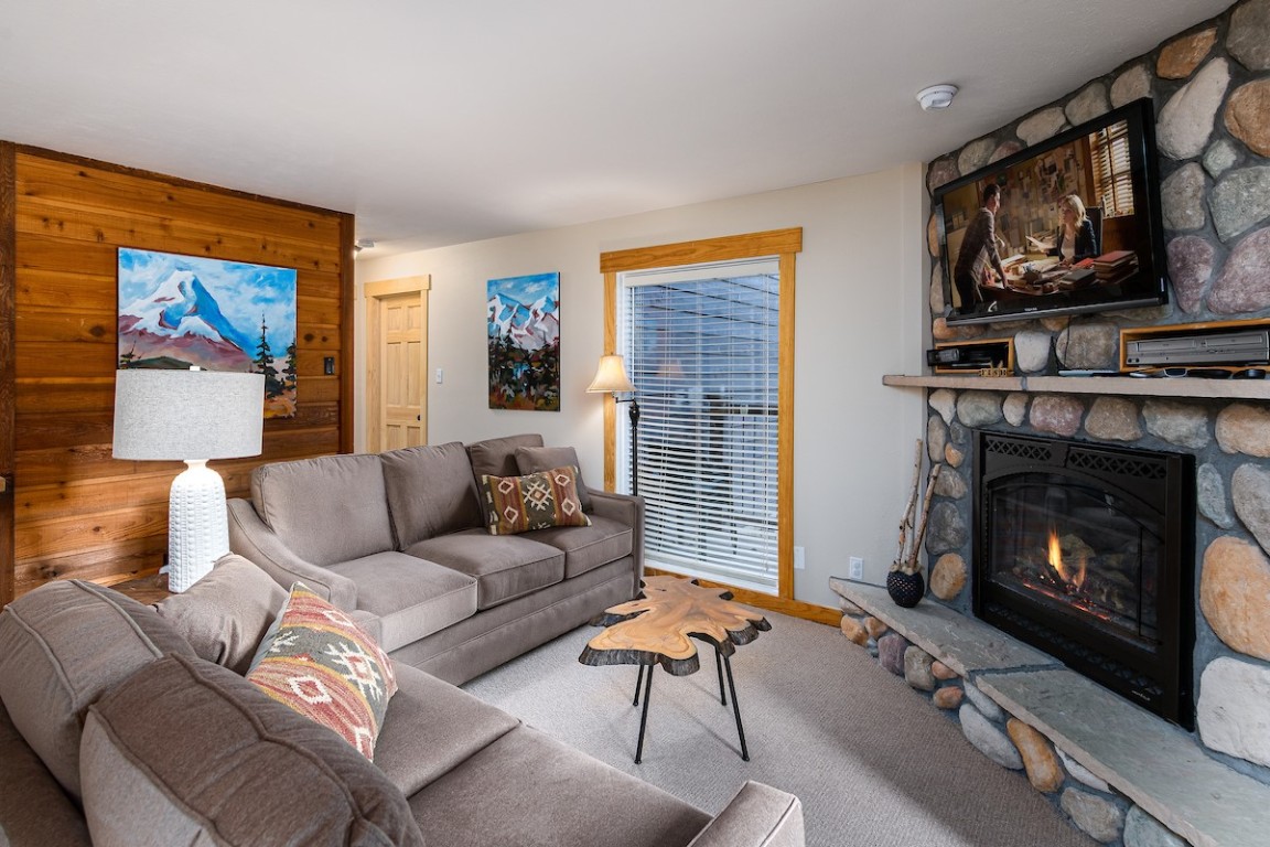 500 4 O Clock Road, Unit A22 Breckenridge, CO 80424 - Photo 14 of 16 a living room with furniture a flat screen tv and a fireplace