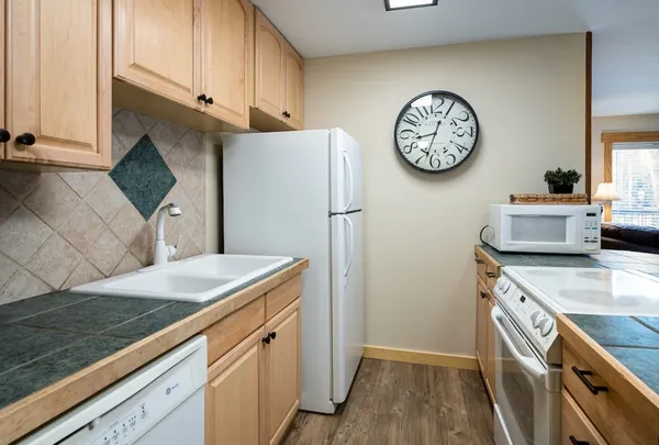 a kitchen with stainless steel appliances granite countertop a refrigerator and a stove