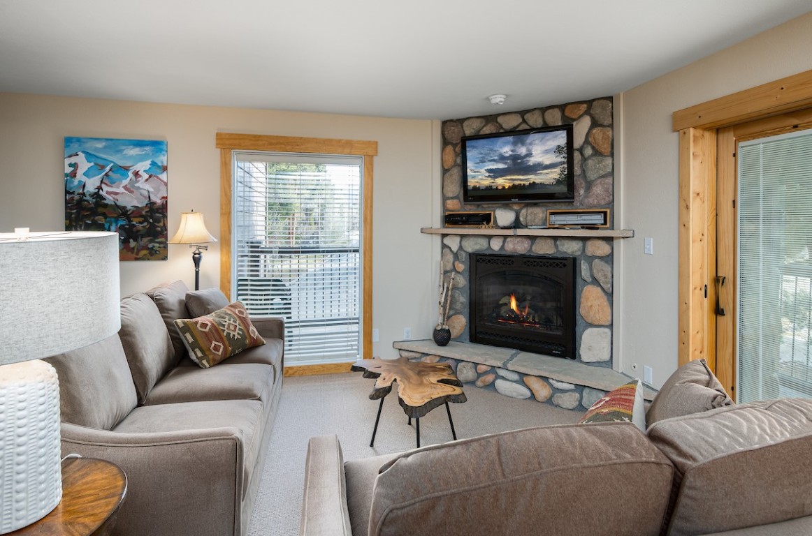 500 4 O Clock Road, Unit A22 Breckenridge, CO 80424 - Photo 9 of 16 a living room with furniture a flat screen tv and a fireplace