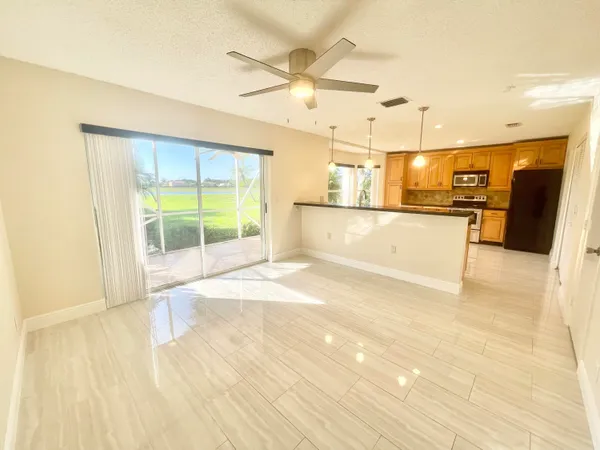 a view of a kitchen with wooden floor and a ceiling fan