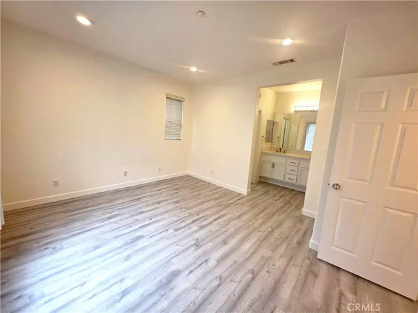 an empty room with wooden floor and entrance