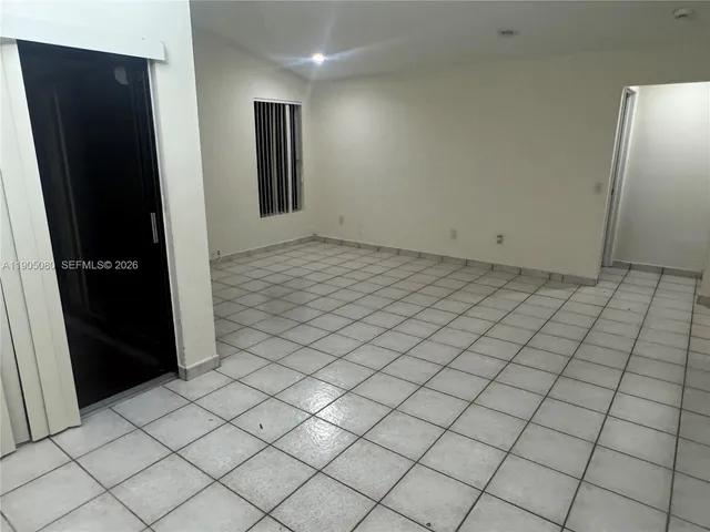 an empty room with chandelier fan