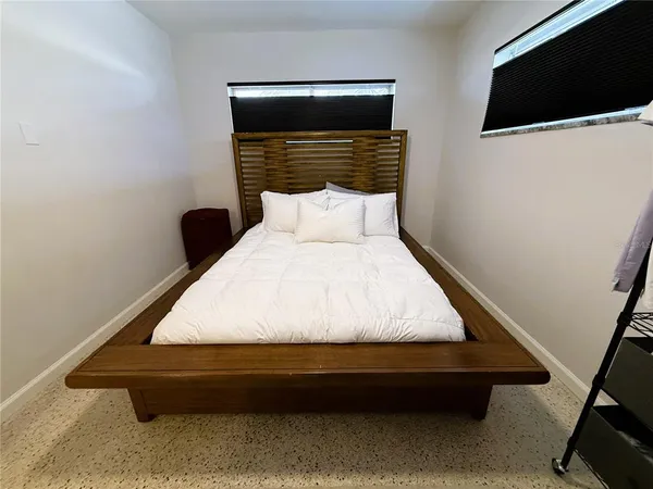 a bed sitting in a bedroom next to a tv