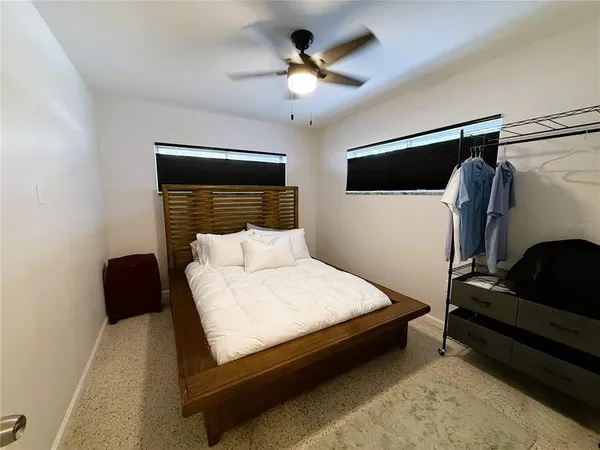 a bedroom with a bed and a ceiling fan