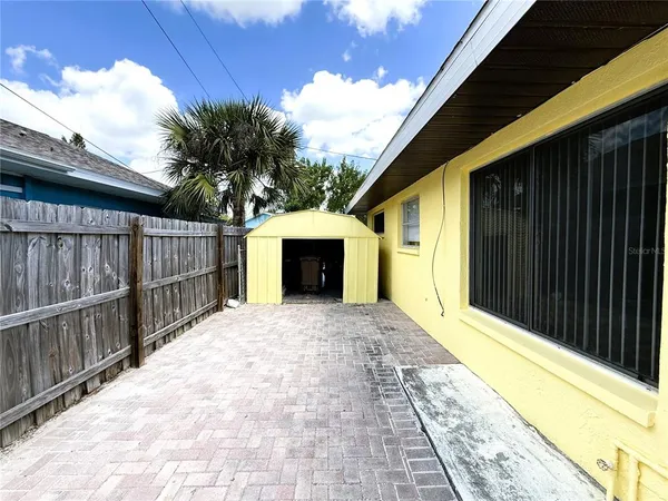 a view of backyard with small cabin and wooden fence