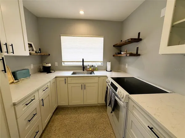 a kitchen with a sink cabinets and window