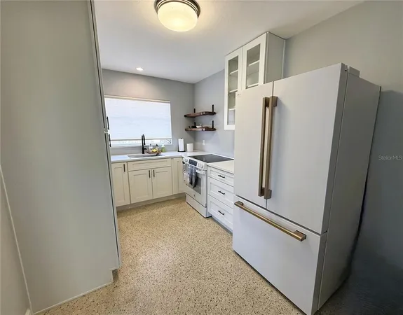 a kitchen with white cabinets and white appliances