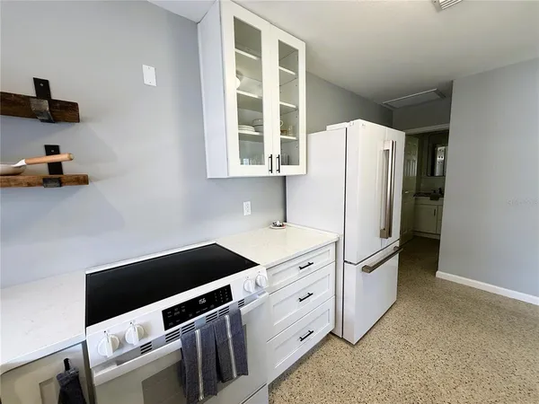 a kitchen with granite countertop cabinets and refrigerator