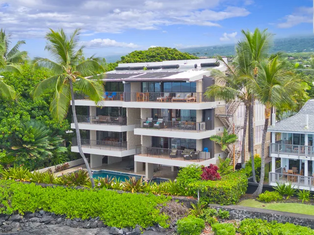 a front view of a multi story building with a yard