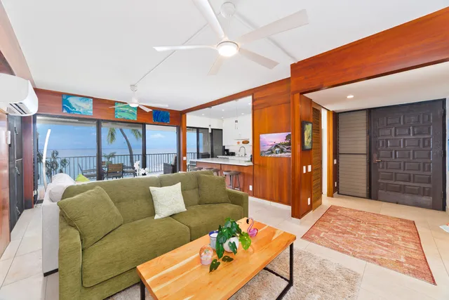 a living room with furniture a ceiling fan and a rug