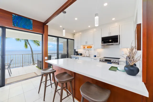 a kitchen with a sink a stove and chairs