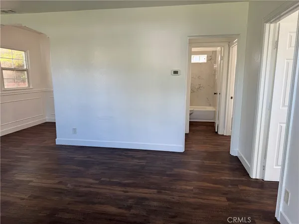 a view of a room with wooden floor and a bathroom