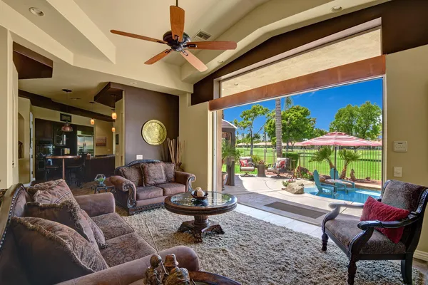 a living room with patio furniture and a floor to ceiling window