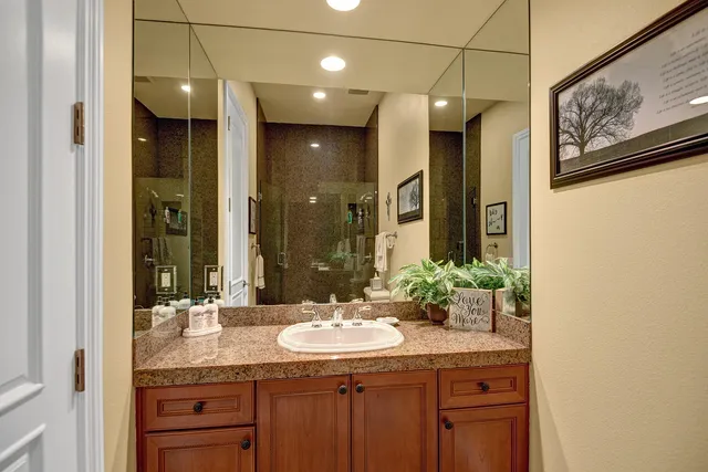 a bathroom with a granite countertop sink and a mirror