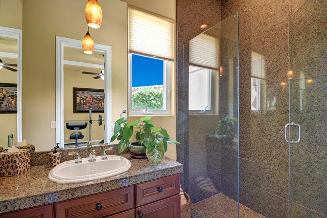 a bathroom with a granite countertop sink and a mirror