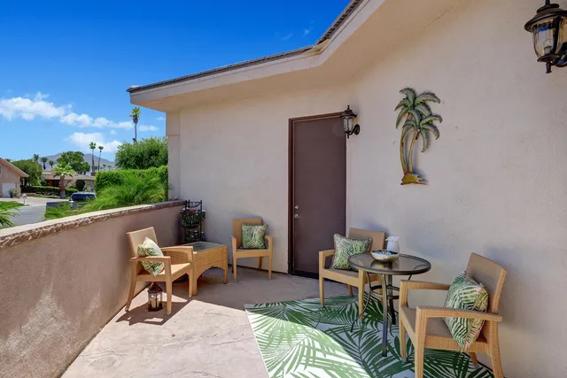 a balcony with couple of chairs and a couch