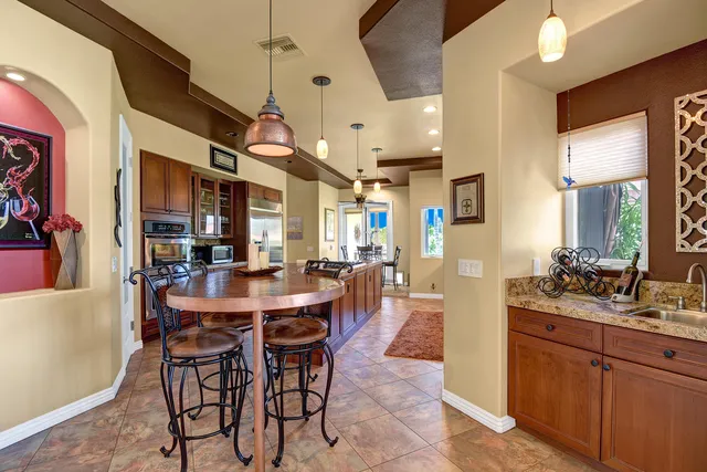 a view of a dining room and livingroom with furniture wooden floor a chandelier