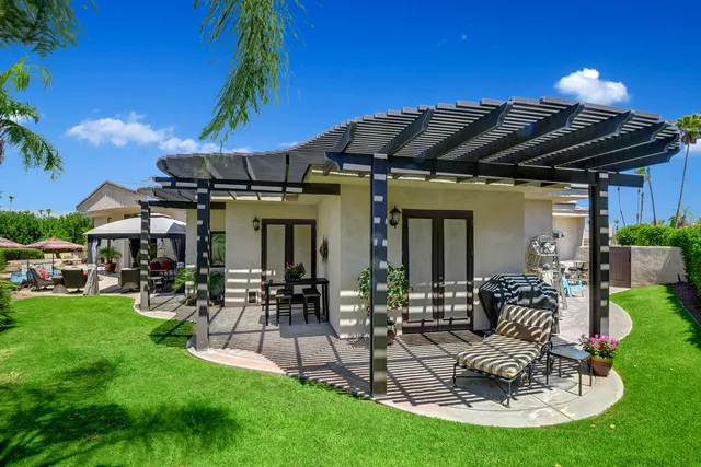 a view of a house with backyard water fountain and sitting area