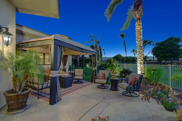 a view of a patio with a table and chairs under an umbrella