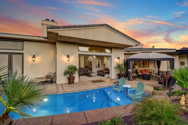 a view of a patio with a table and chairs under an umbrella