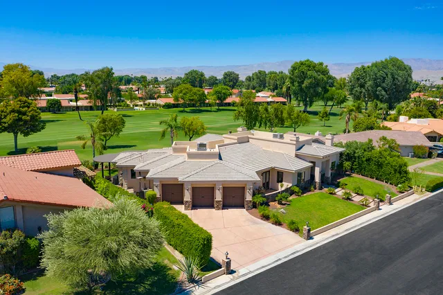 an aerial view of a house with a garden and trees