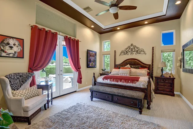 a bedroom with a bed a large window and couch