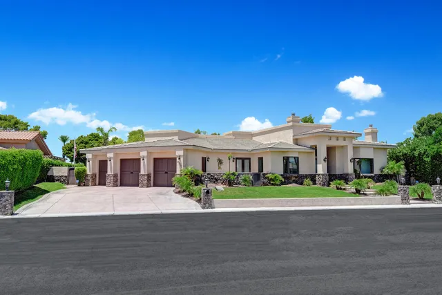 a front view of a house with a garden and plants