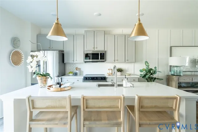 a kitchen with kitchen island granite countertop a sink cabinets and stainless steel appliances