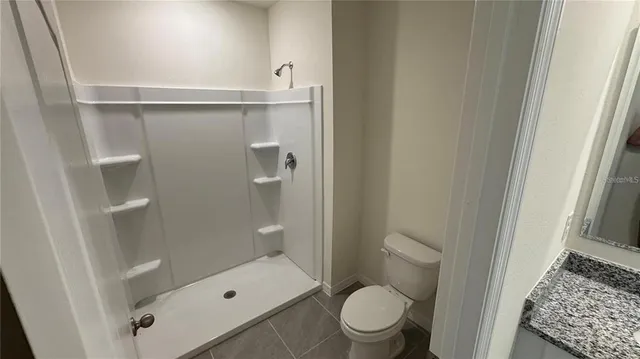 a bathroom with a toilet and a shower