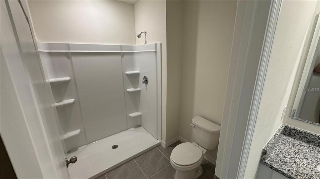 1446 Isleta Loop Kissimmee, FL 34741 - Photo 12 of 27 a bathroom with a toilet and a shower