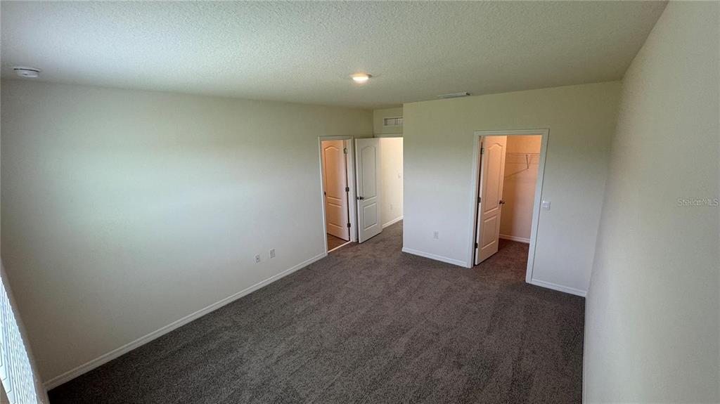 1446 Isleta Loop Kissimmee, FL 34741 - Photo 15 of 27 an empty room with closet and wooden floor