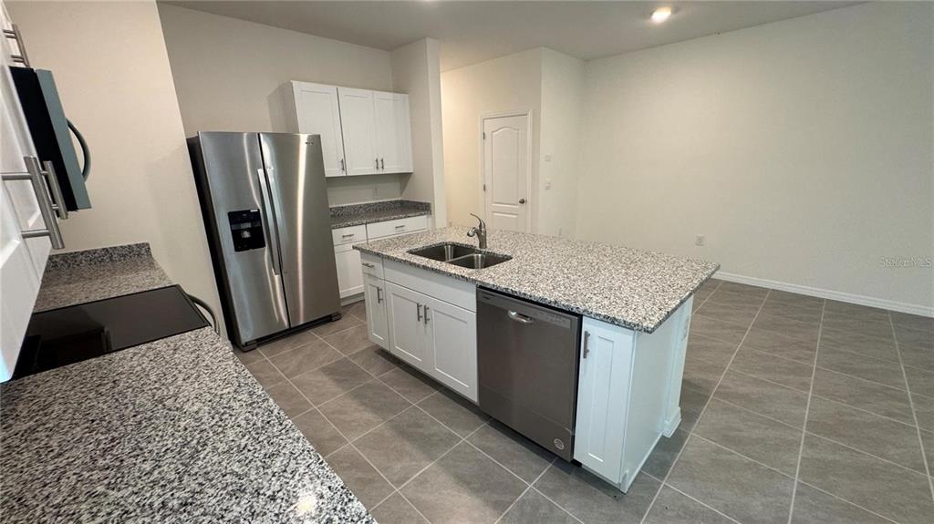 1446 Isleta Loop Kissimmee, FL 34741 - Photo 2 of 27 a kitchen with stainless steel appliances granite countertop a sink stove and refrigerator