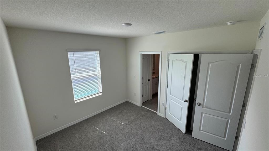 1446 Isleta Loop Kissimmee, FL 34741 - Photo 21 of 27 an empty room with windows and closet