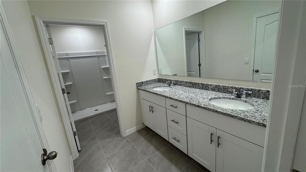 1446 Isleta Loop Kissimmee, FL 34741 - Photo 9 of 27 a spacious bathroom with a granite countertop sink and mirror