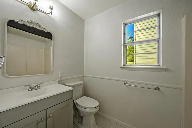a bathroom with a sink toilet and mirror