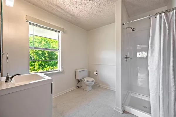 a bathroom with a sink toilet and shower