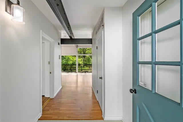 a view of a hallway with wooden floor and staircase