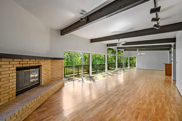 a view of empty room with wooden floor and fireplace