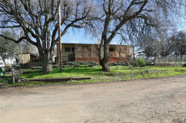 a view of a house with a yard and large trees